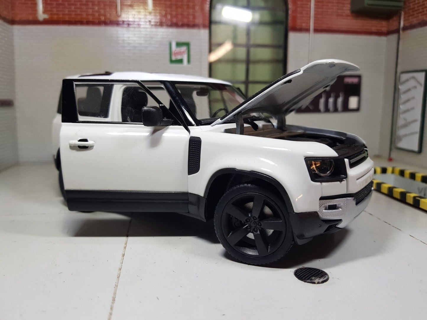 Front quarter view of a 2020 Land Rover Defender model in white with black trim and wheels. The bonnet and side door are open.