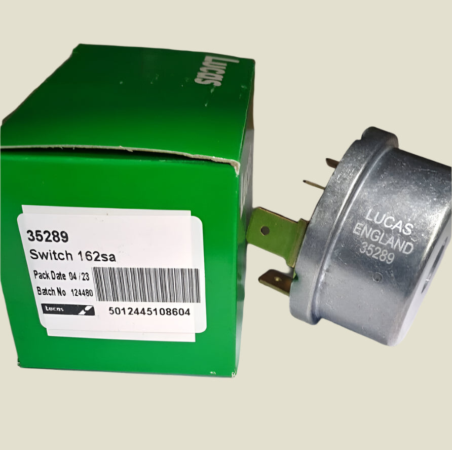 A green Lucas box with "35289 Switch 162sa) written on the side. Next to the box is the ignition switch, with "LUCAS ENGLAND 35289" written on the side.