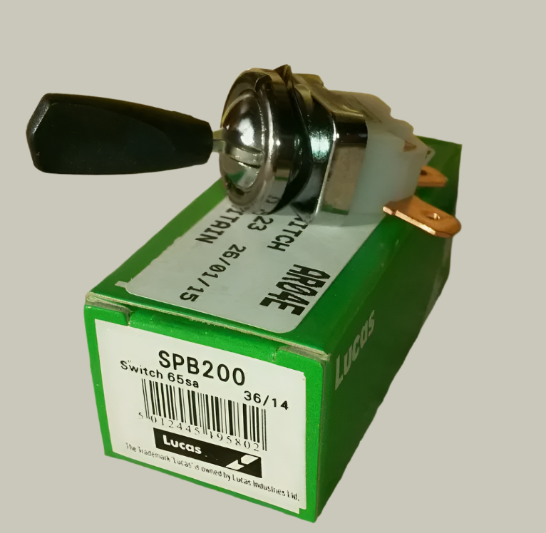 Side view of a Lucas toggle switch, sat on a Green Lucas box with "SPB200 Switch 65sa" written on the side of the box.