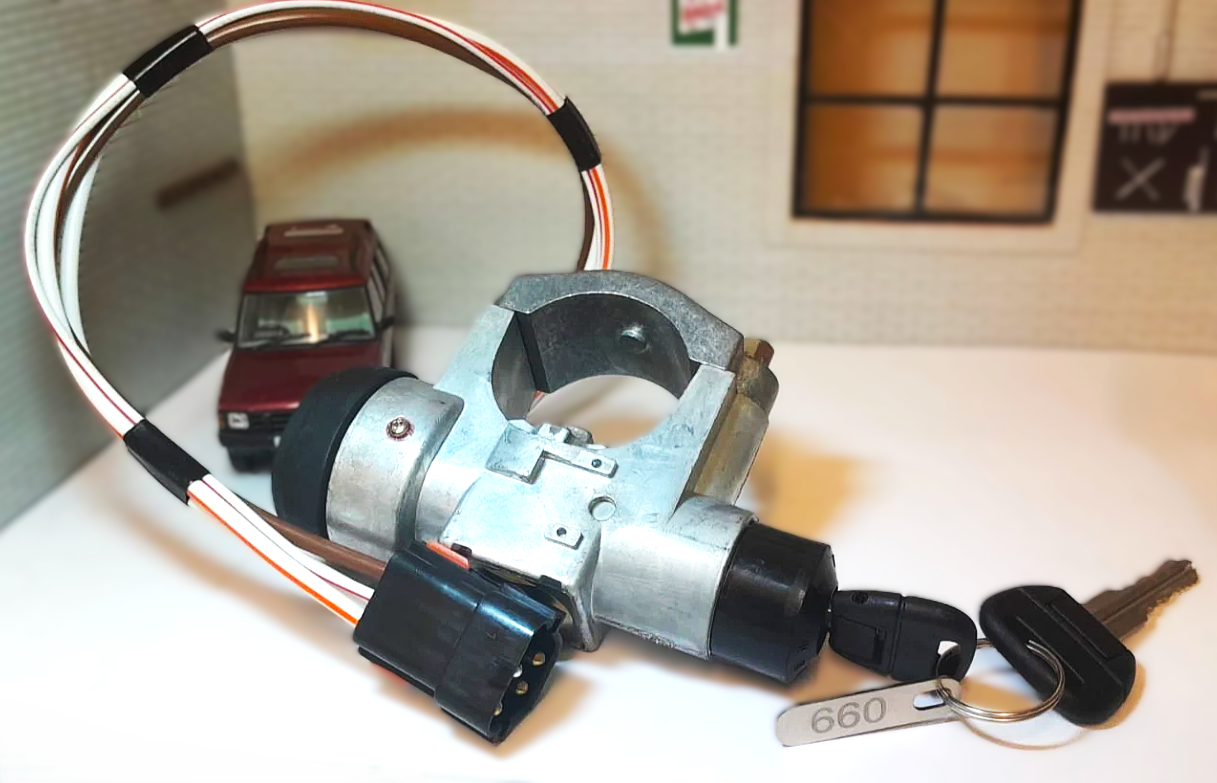 Car ignition switch with wiring and keys on a white surface