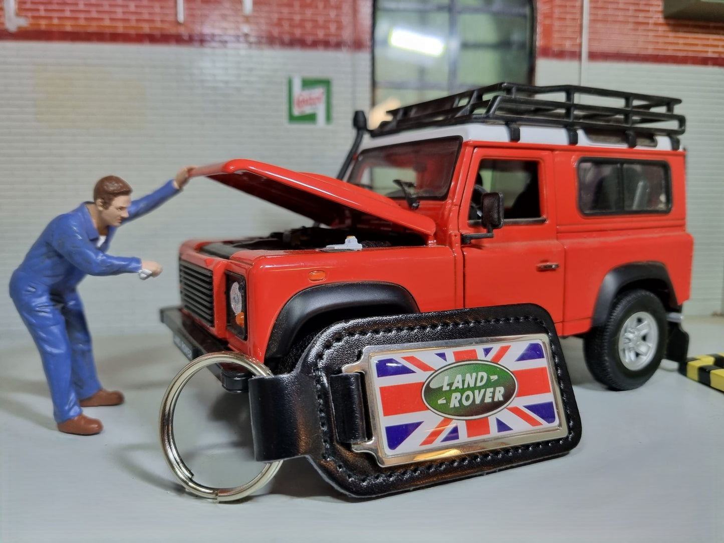 A Land Rover Key Ring. The Green oval logo sits on a Union Jack background which are attached to a leather fob.