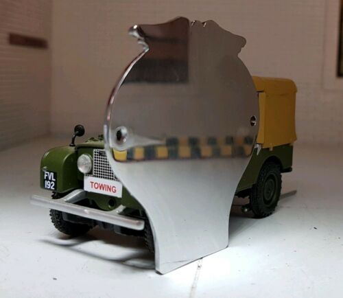 The back side of a half scale AA badge, showing a shiny chrome style finish.