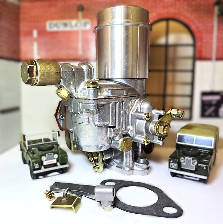 Carburetor with gasket and small model cars on a white surface