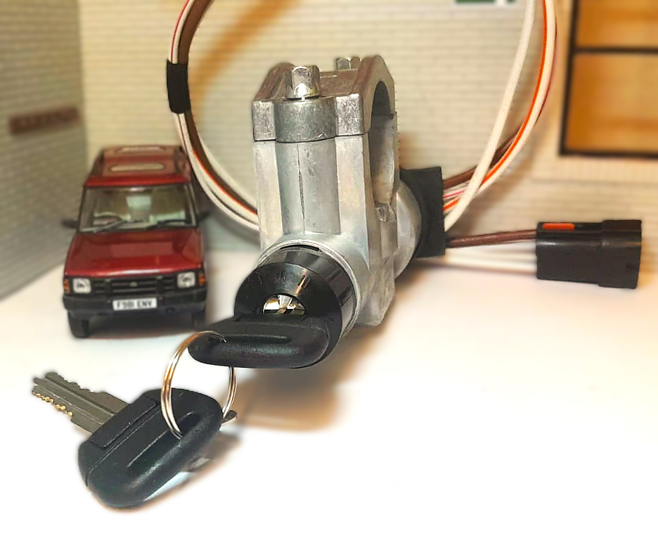 Car ignition switch with keys and wiring on a blurred background